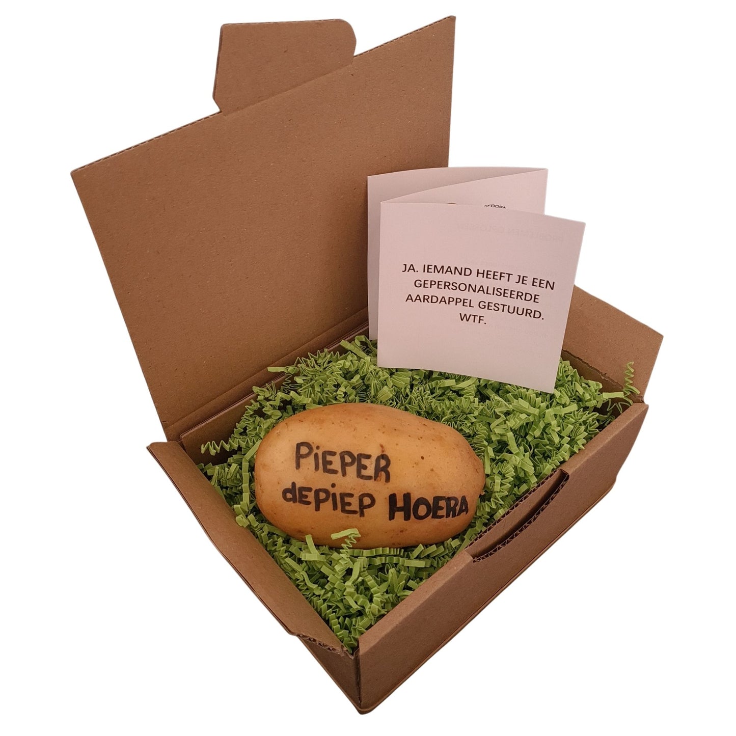 Een pakket met daarin een aardappel met daarop de tekst handgeschreven in zwarte inkt “pieper de piep hoera”. Een wit zigzak boekje met de tekst “Ja, iemand heeft je een gepersonaliseerde aardappel gestuurd. WTF.” Verpakt in een hysterisch groen verpakkingsmateriaal.