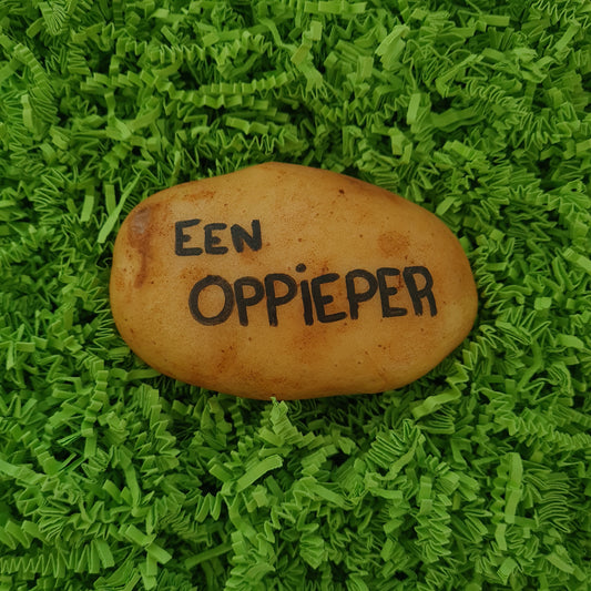 Een aardappel met daarop handgeschreven "een oppieper" in zwarte inkt. in hysterisch groene verpakking.